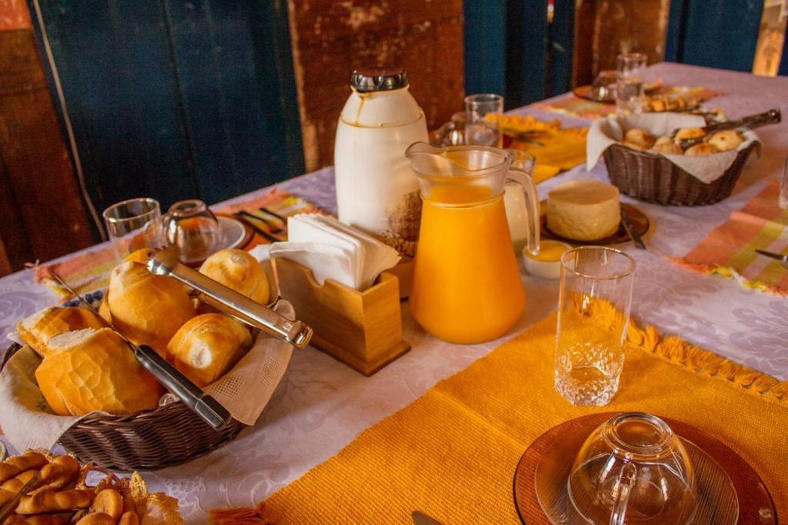 Mesa do café com pães, suco, queijo e quitutes caseiros